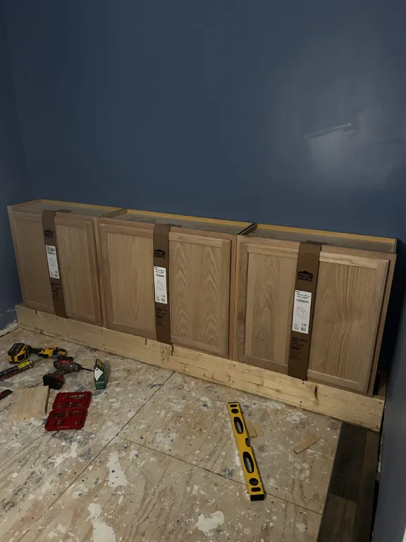 Base cabinets staged for a built-in bookshelf