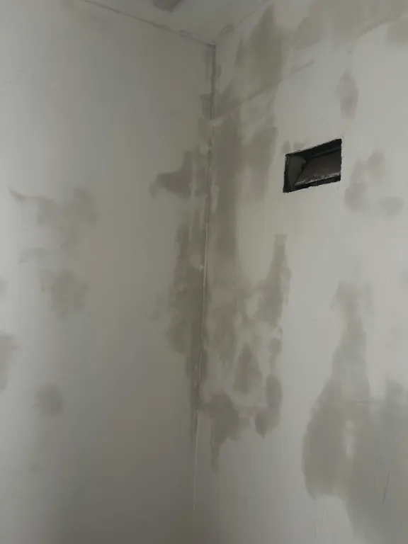 Drywall corner with joint compound patches and a vent opening