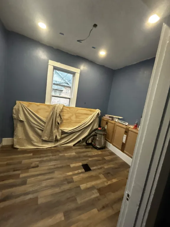 Finished room with plank flooring and recessed lighting