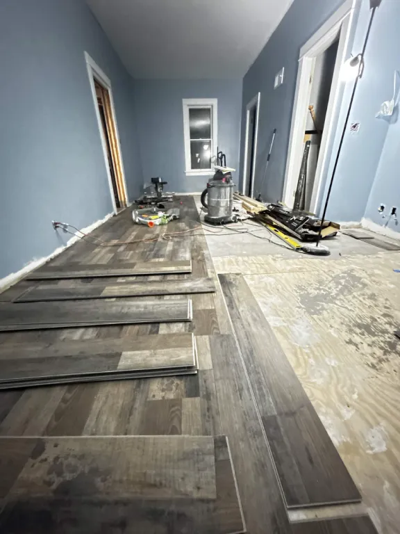 Vinyl plank flooring being installed down a hallway