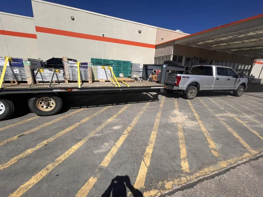 Pallets of flooring staged on a flatbed trailer