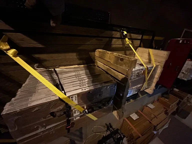 Wrapped flooring bundles strapped to a trailer at night