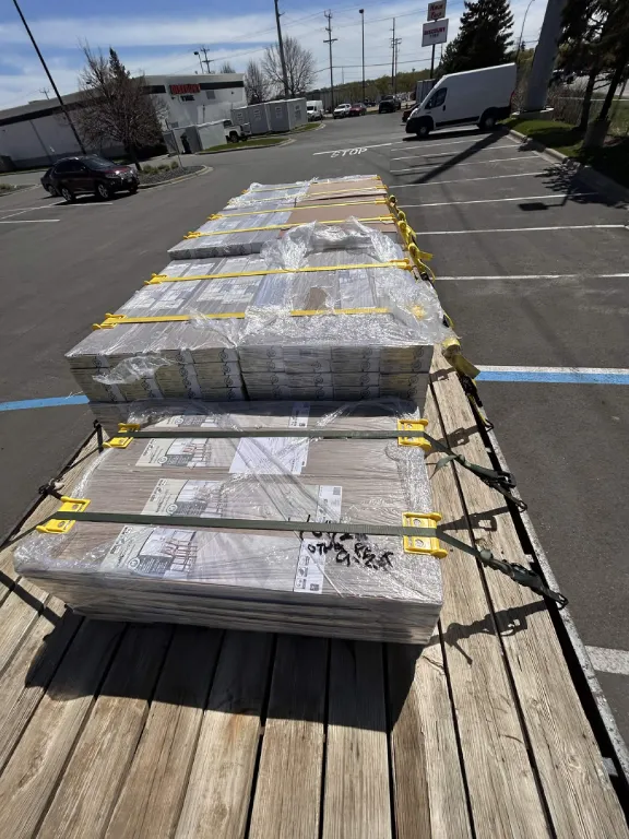 Wrapped stacks of flooring strapped on a trailer