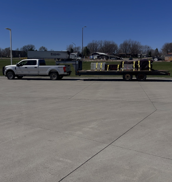 Pickup towing a loaded gooseneck flatbed trailer