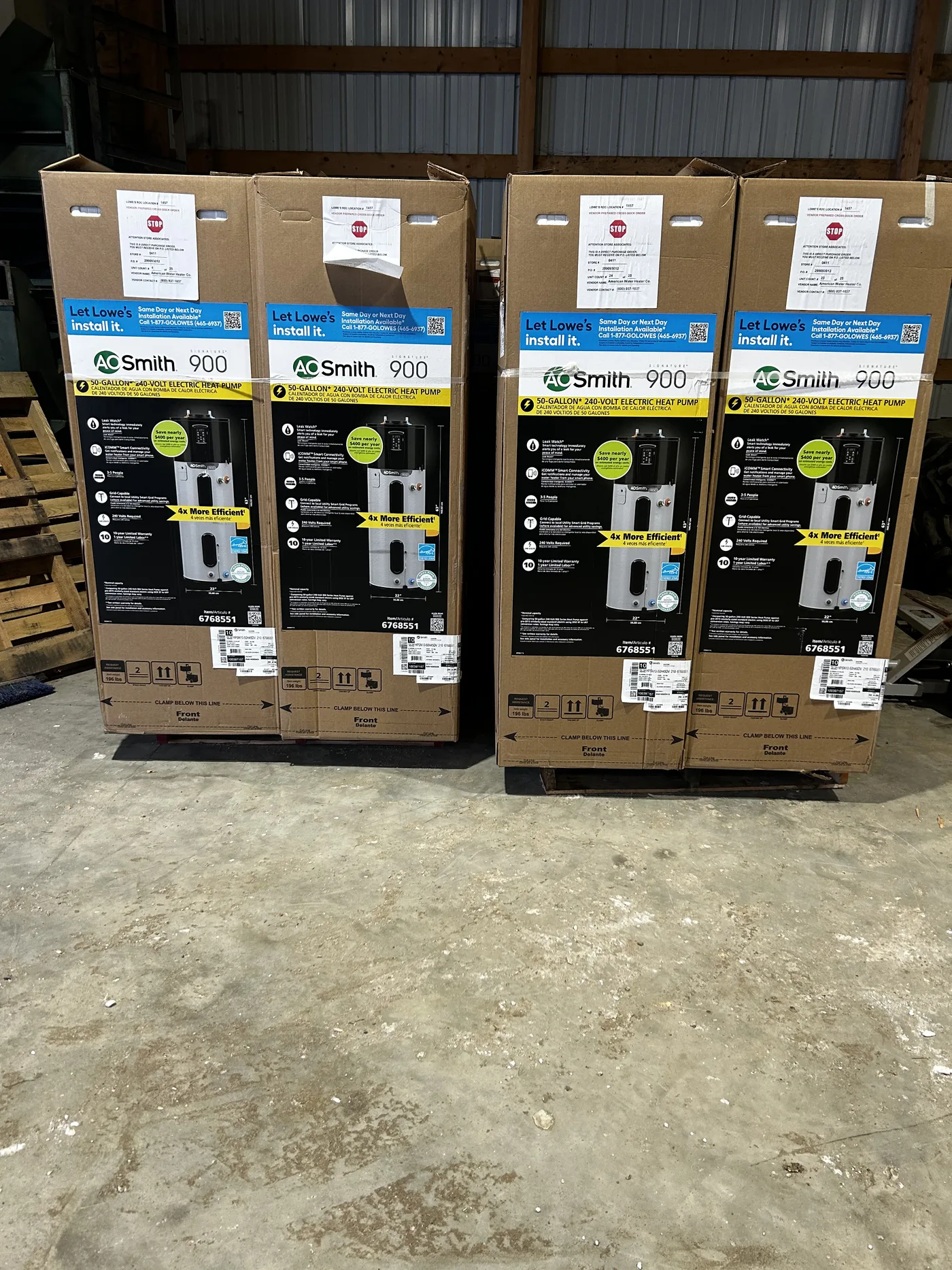 Four sealed A.O. Smith heat pump water heaters on a pallet