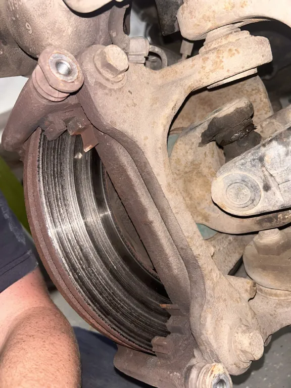 Worn brake rotor exposed with the caliper removed