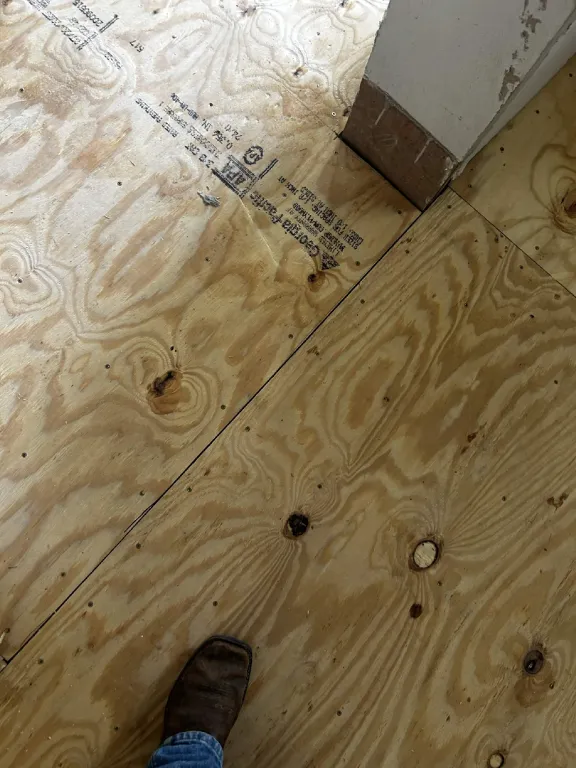 Fresh plywood subfloor screwed down in a doorway
